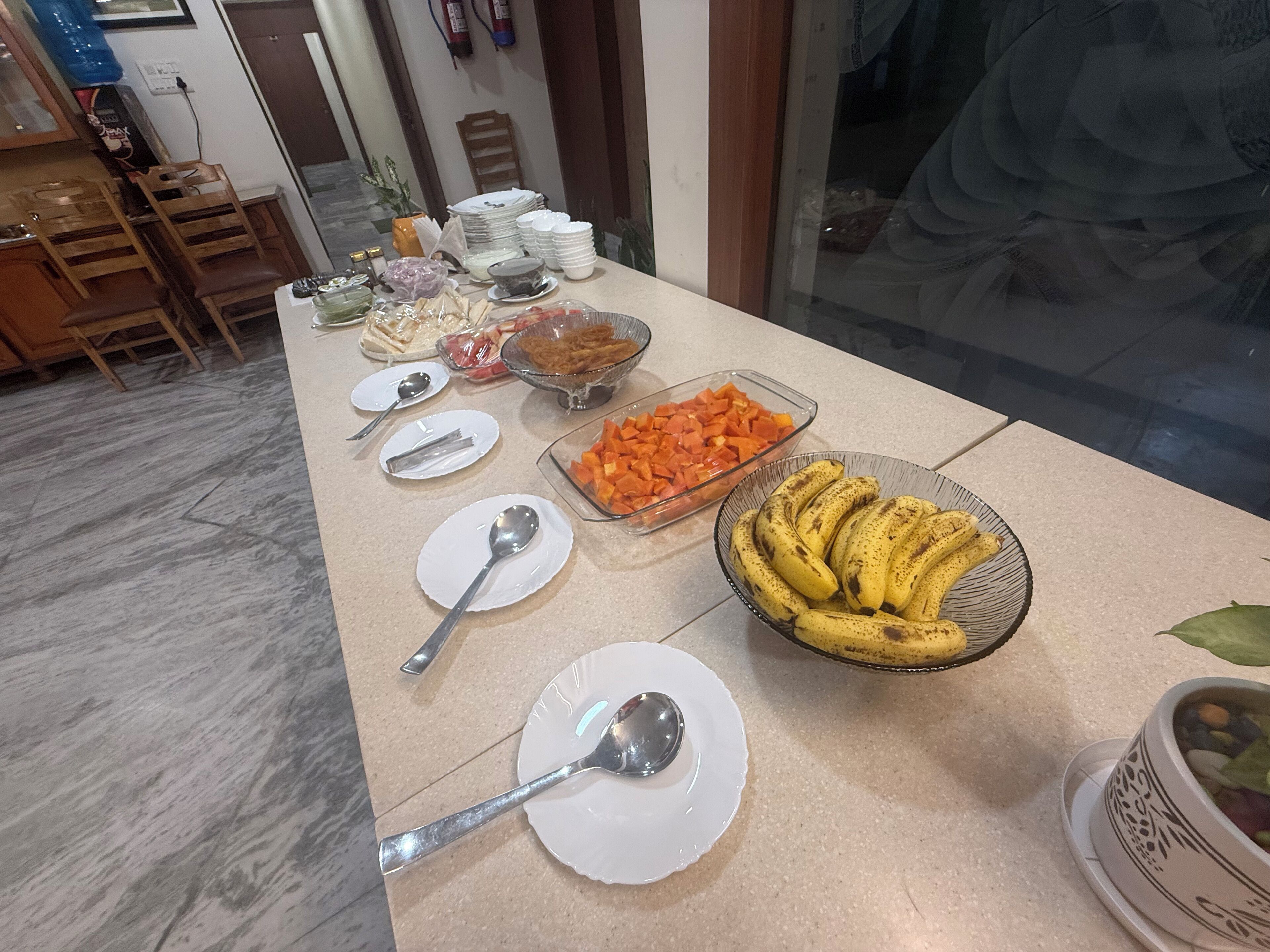 A buffet table with various food items and utensils.