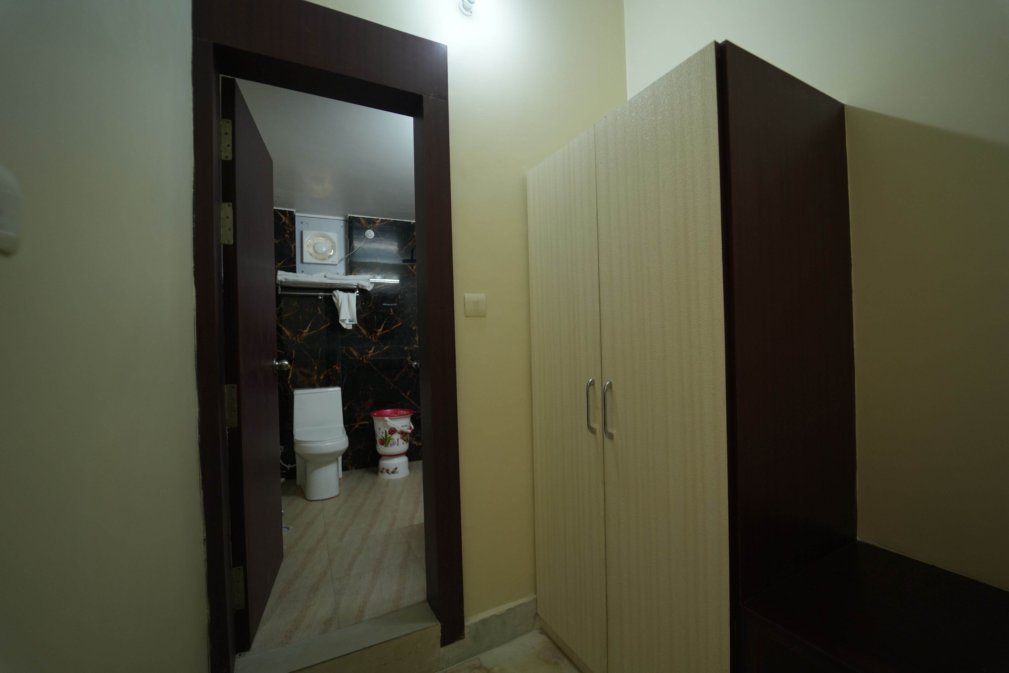 Una habitación con armario, una puerta que da al baño y una lámpara.