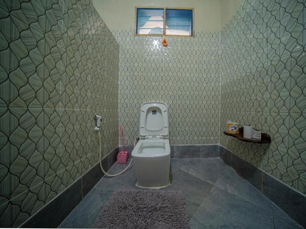 A bathroom with a toilet, a shower, and a sink.