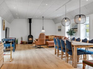 Un grand salon doté d’une cheminée, d’une table à manger avec des chaises et d’un canapé.
