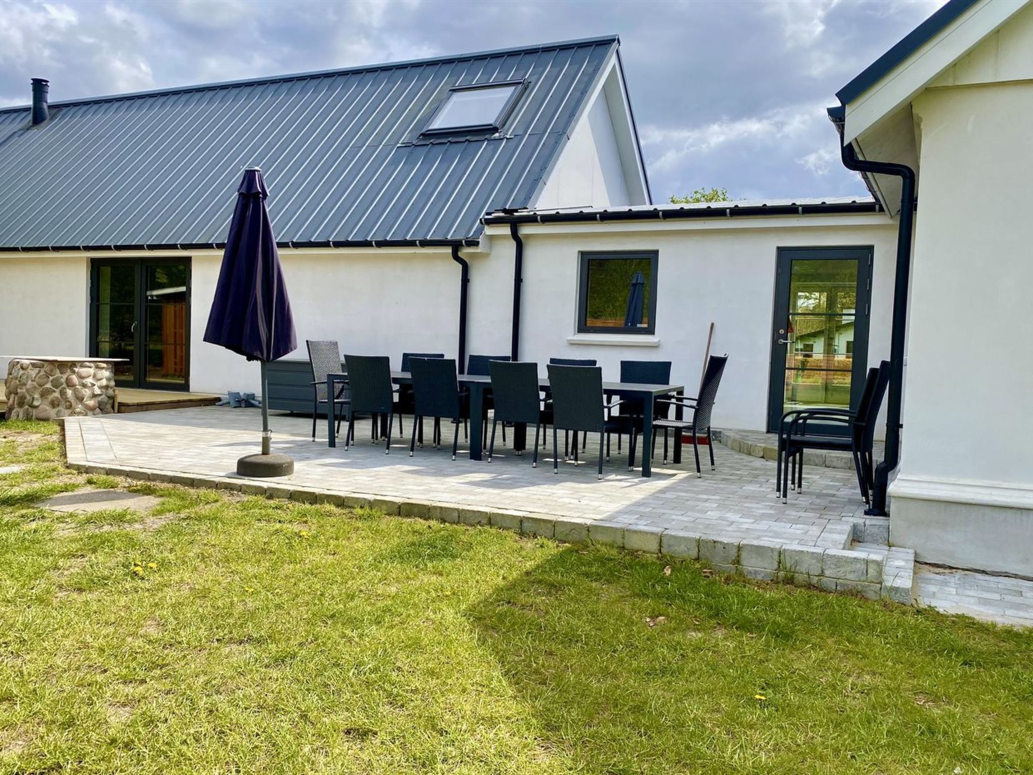 A house with a patio, outdoor seating, and a metal roof.