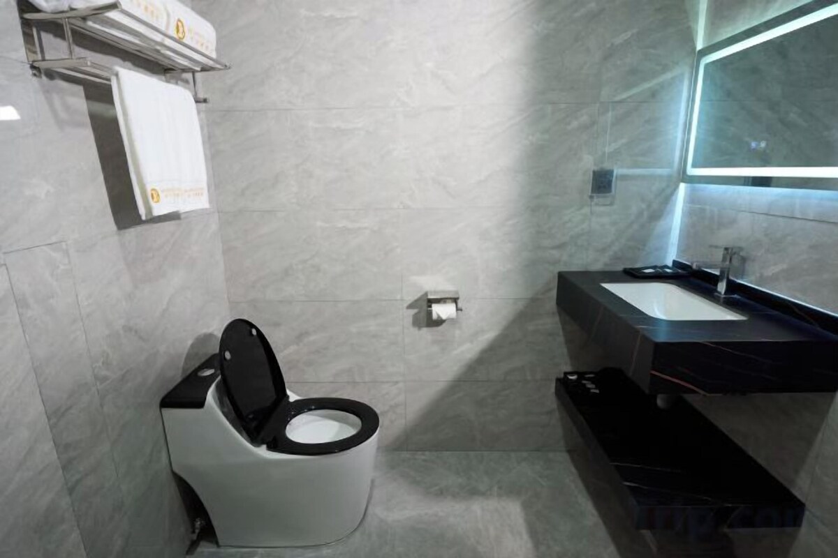 A modern bathroom with a toilet, sink, and mirror.