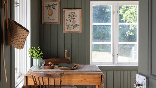 A wooden dining table with chairs, a hanging basket, and framed botanical prints on the wall. - Cozy vacation home on Öland, close to nature and the sea (Kalmar län)