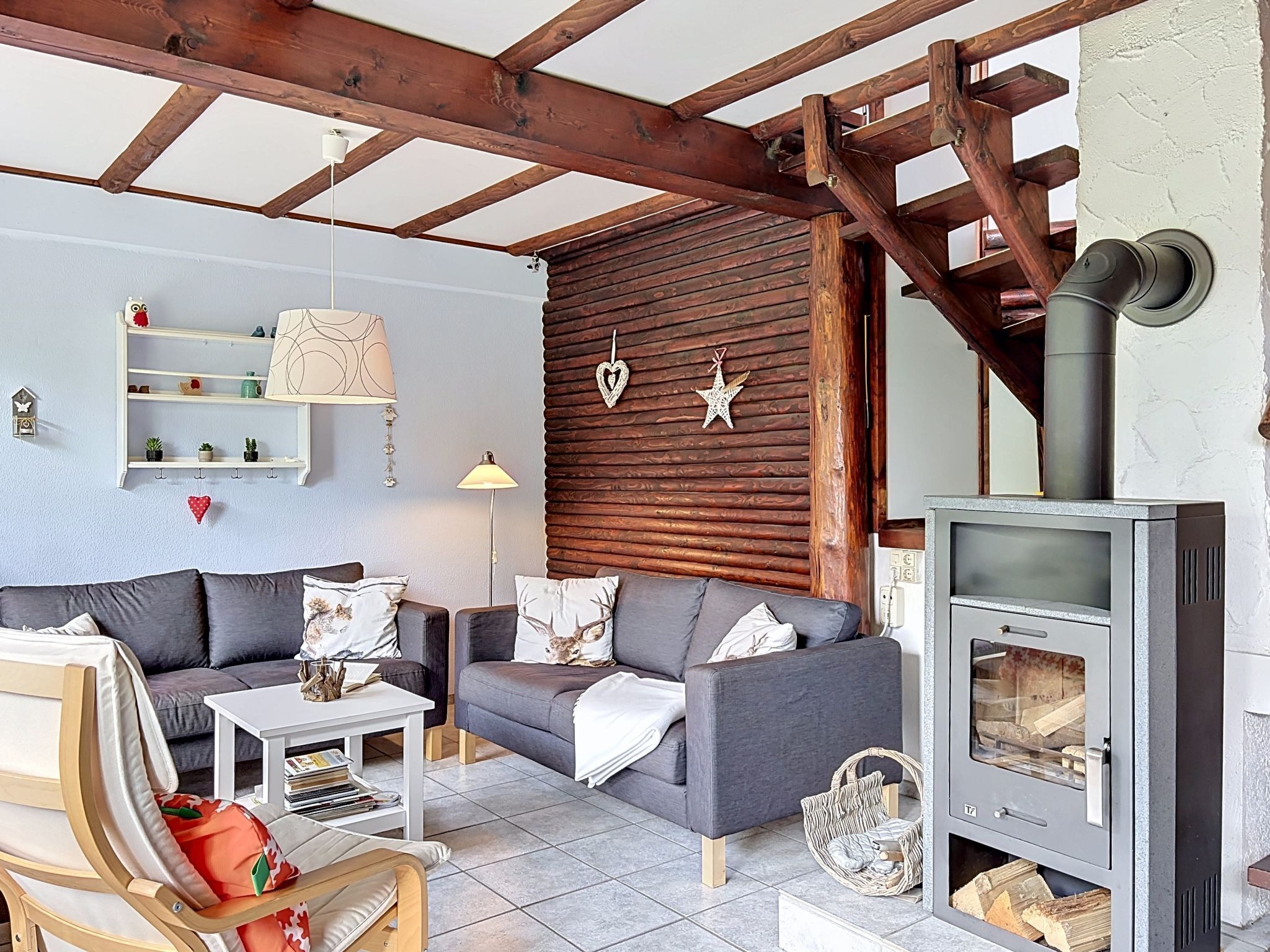 Una sala de estar acogedora con un sofá, una mesa de centro, una chimenea y un techo de madera.