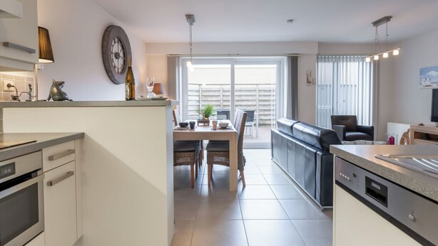A modern kitchen with a dining area, a sofa, and a TV. - Zandloper III with terrace by Interhome (Bredene)