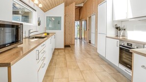 Una cocina moderna con armarios de madera, horno empotrado y un amplio ventanal.
