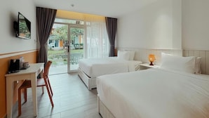 A hotel room with two beds, a desk with a chair, a TV mounted on the wall, and a window with curtains. - The Signature Retreat & Pool Phu Quoc (Phu Quoc)