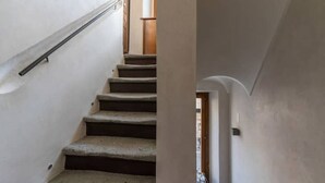 A staircase with a handrail, leading to a landing.