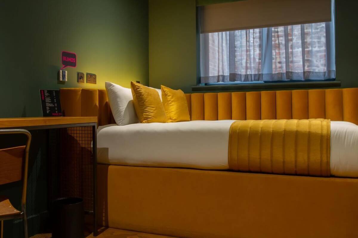 A compact room with a bed, a desk, and a chair.