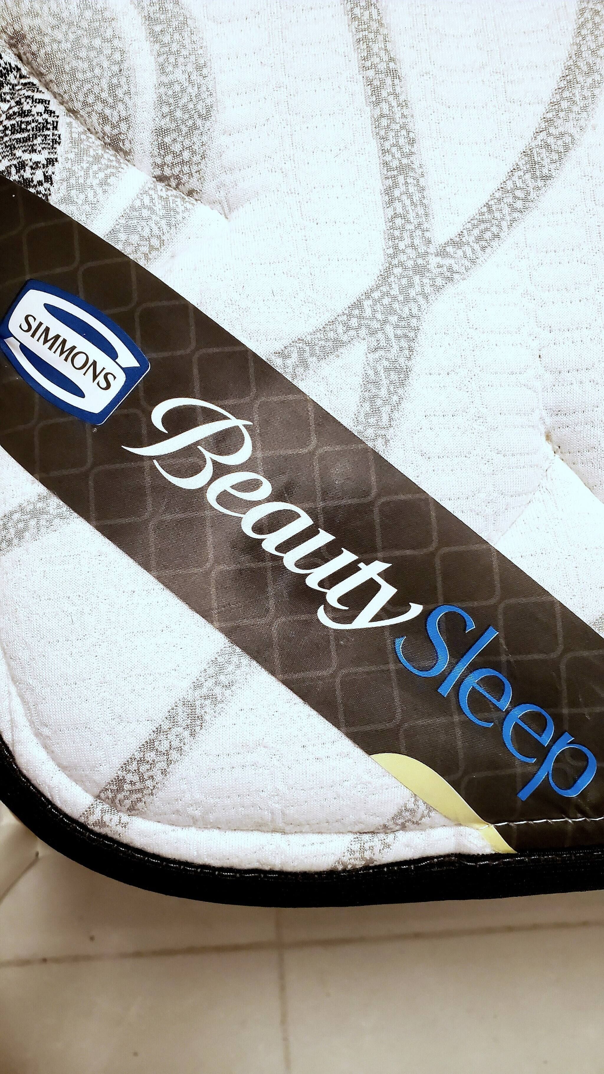 A pillow with a label that reads "Beauty Sleep" and a logo that says "SIMMONS".