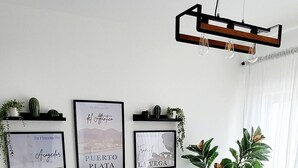 A living room with a sofa, two coffee tables, and framed artwork on the wall. - 2BR 2BA Backup Power AC Wifi Gym 24h Security Ideal for Long Stays (Santiago de los Caballeros)