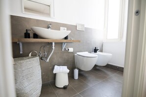 A modern bathroom with a large sink, a toilet, and a bidet. - Elegante appartamento in centro città (Reggio Calabria)