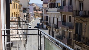 Una calle estrecha flanqueada por edificios con balcones, bajo un cielo despejado.