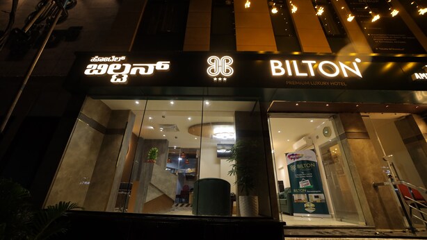 El exterior de un hotel con un cartel grande que dice 'BILTON' y un cartel más pequeño que indica 'BILTON PREMIUM LUXURY HOTEL'.