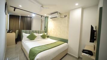 Une chambre d’hôtel moderne dotée d’un grand lit, d’un bureau avec un téléphone et d’un ventilateur de plafond.
