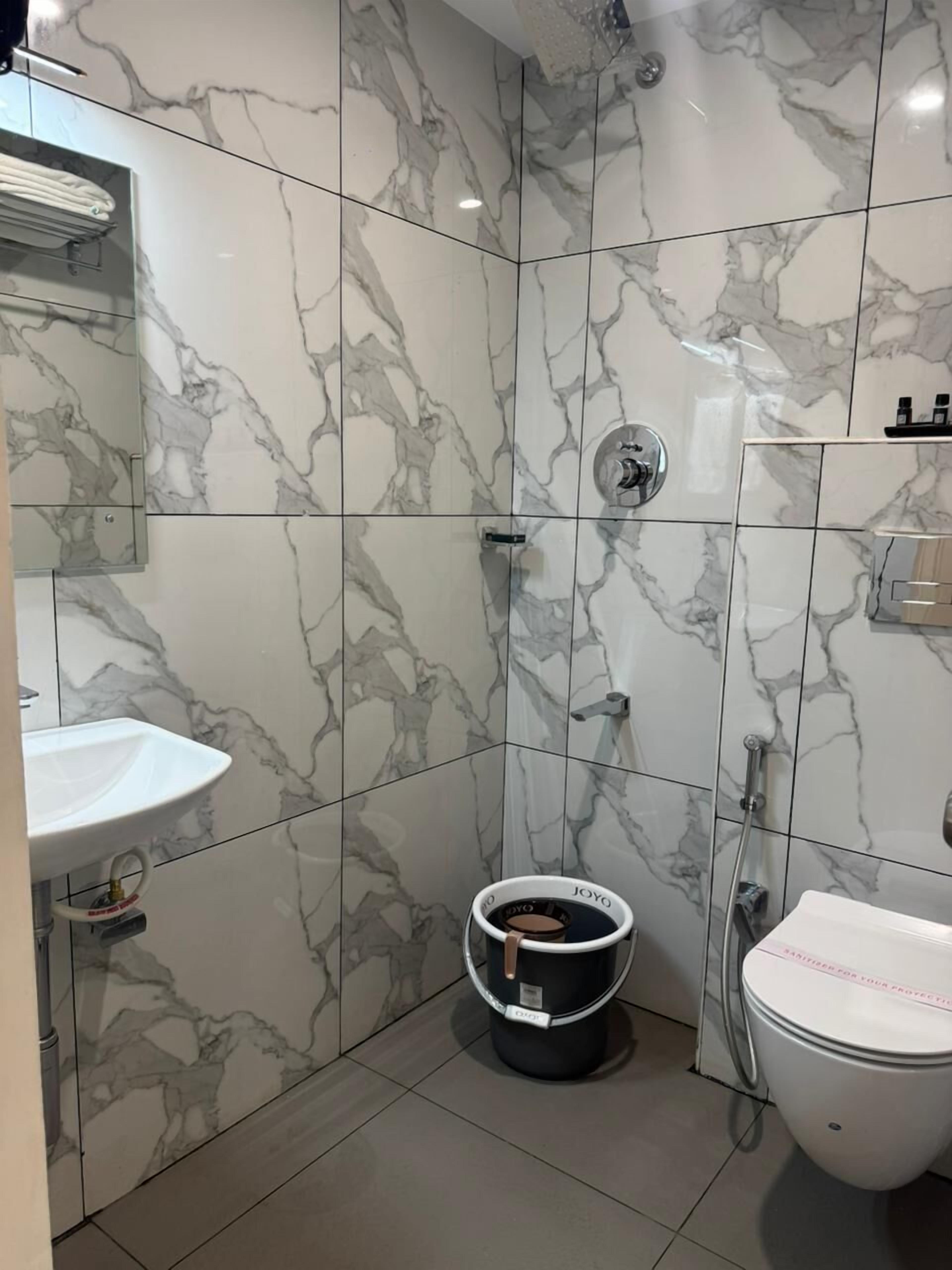 Une salle de bain avec un lavabo blanc, des toilettes et une douche.