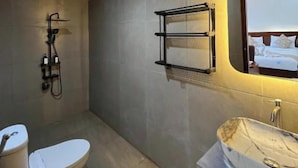 Een moderne badkamer met toilet, douche en wastafel.