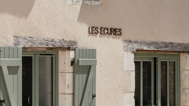 Un edificio con un cartel que dice "LES ECURIES".