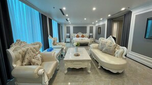 Un salon spacieux avec une table basse au centre, deux canapés et un grand lit en arrière-plan.