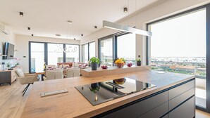 Una cocina moderna con una isla grande, electrodomésticos integrados y vistas a la ciudad.