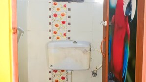 A bathroom with a toilet, a small window, and a decorative panel. - New Balagi Guest House (Barakpur)