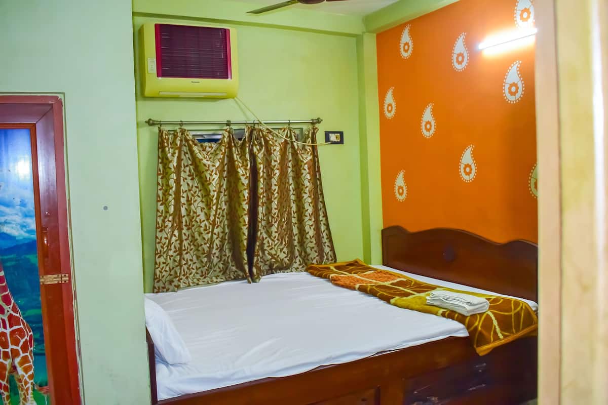 A room with a bed, a window with curtains, an air conditioning unit, and a wall with a decorative pattern.