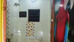 A small bathroom with a toilet, a shower, and a sink. - New Balagi Guest House (Barakpur)