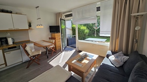 En moderne stue med sofa, sofabord og et spiseområde med bord og stole.