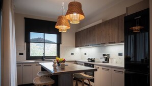 A modern kitchen with a central island, wooden cabinets, and a large window.