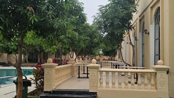Un patio con piscina, una fuente y un edificio con balcón.