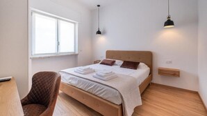 A bedroom with a bed, a chair, a bedside table, a window, and two pendant lights. - One step away from Juliet's House, Piazza Erbe and Ponte Pietra quiet area (Verona)