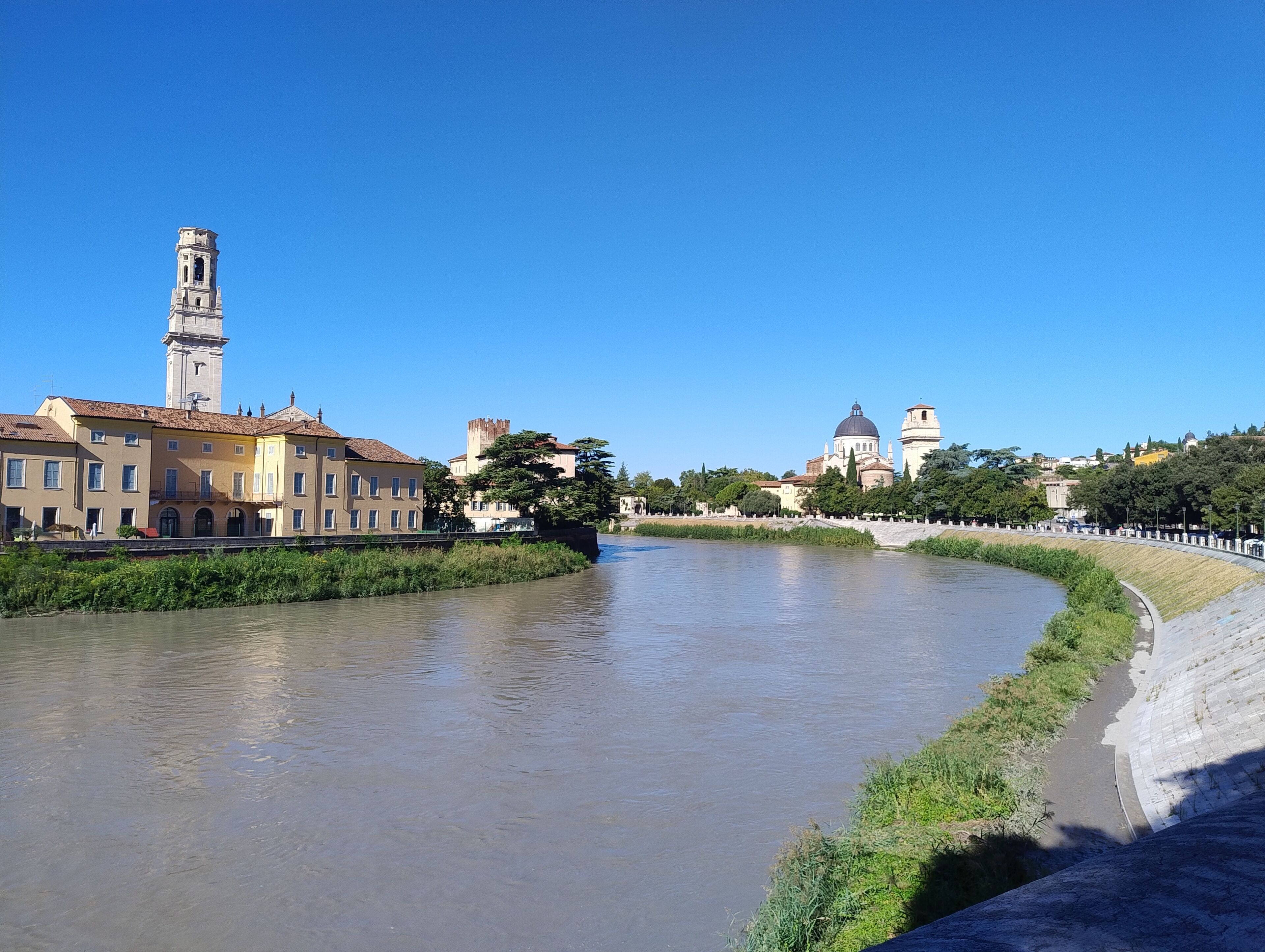A river with buildings on one side and a tower on the other.
