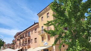 A building with multiple balconies and a café with outdoor seating. - One step away from Juliet's House, Piazza Erbe and Ponte Pietra quiet area (Verona)