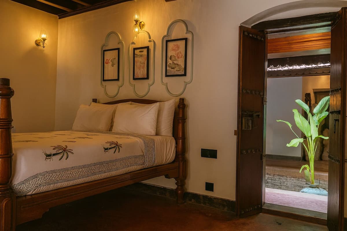 Ein Schlafzimmer mit einem hölzernen Bett, einer Wandleuchte und gerahmten Kunstwerken.
