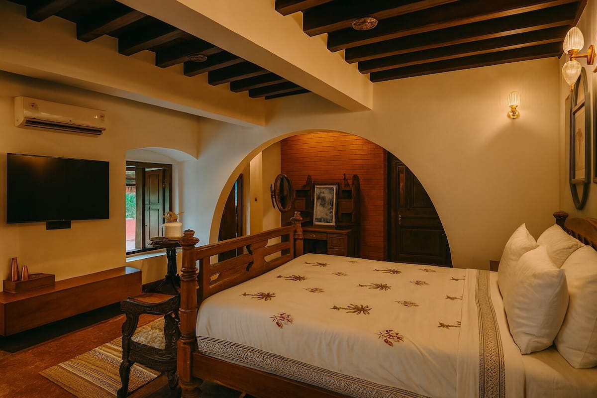 Ein Schlafzimmer mit einem hölzernen Bett, einem Fernseher, einem Schreibtisch und einem Kamin.