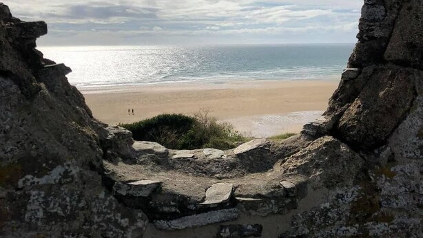 A stone archway framing a beach view with a clear sky and distant horizon. - Welcome to the Terns! The dune house. (Barneville-Carteret)