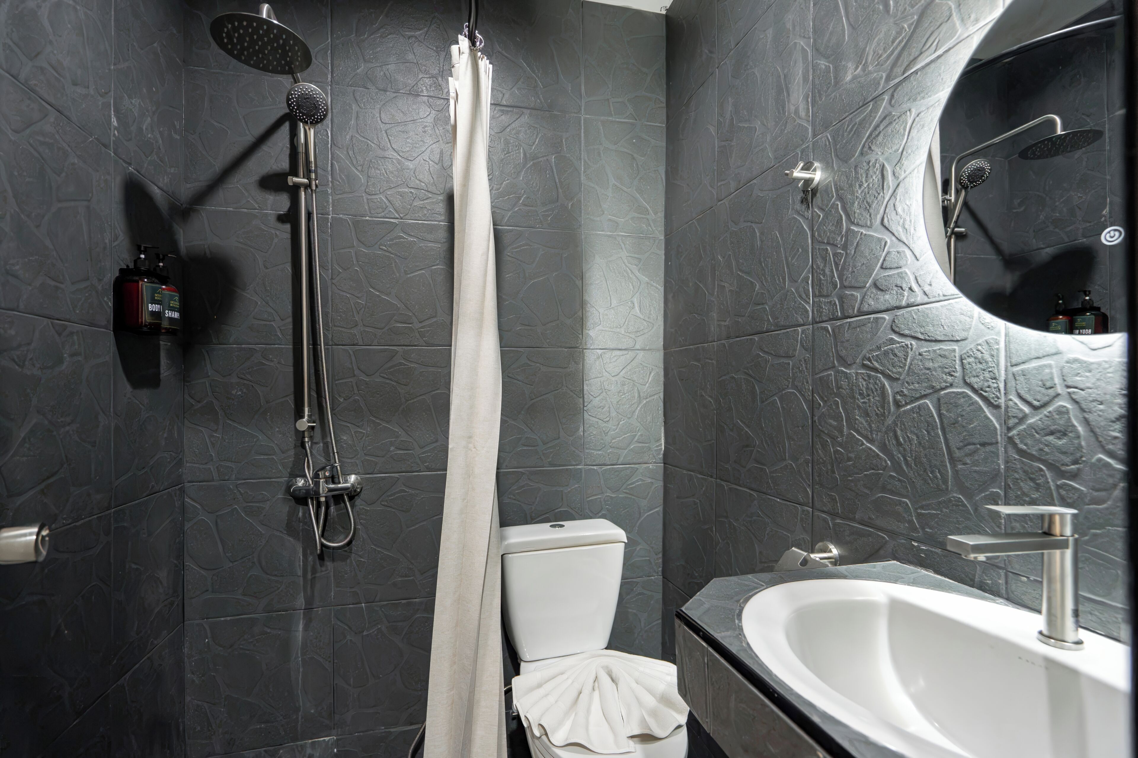 Une salle de bain moderne équipée d’une douche, de toilettes et d’un lavabo.