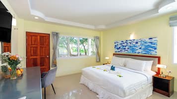 Una habitación de hotel con una cama, un escritorio, una silla, un ventanal con cortinas y un cuadro en la pared.