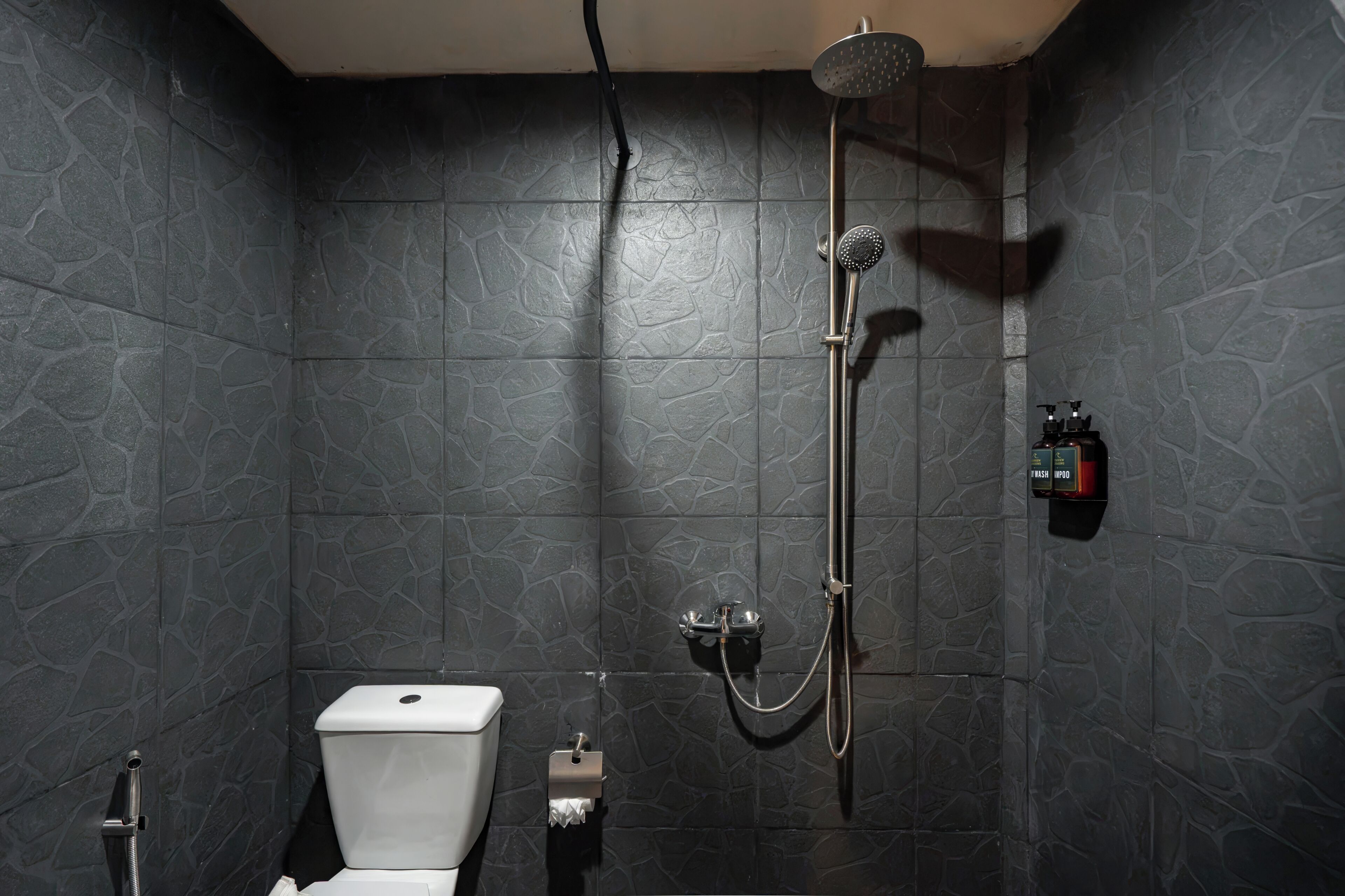 Ein Badezimmer mit Dusche, Toilette und Seifenspender.