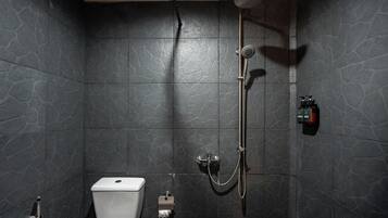 Ein Badezimmer mit Dusche, Toilette und Seifenspender.
