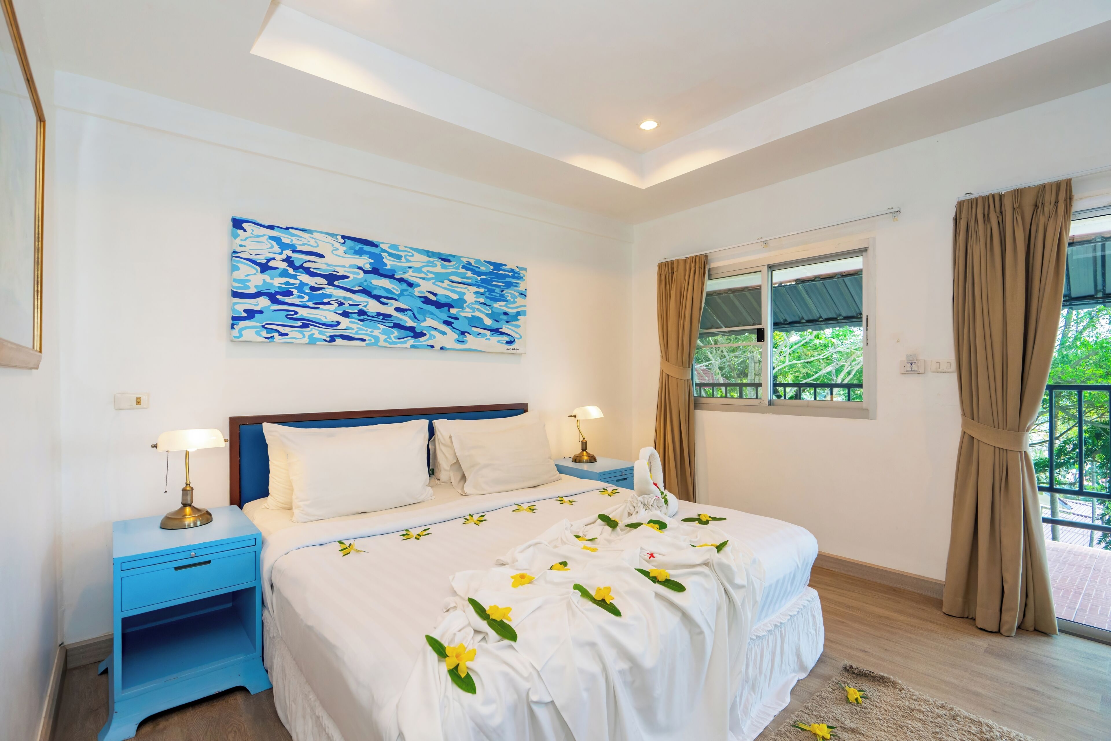 Une chambre d’hôtel avec un lit, deux tables de chevet, une commode, une fenêtre avec des rideaux et un tableau au mur.