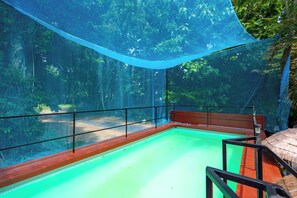 An indoor swimming pool with a glass barrier and a blue canopy. - Oceanview Bungalows by EAT, Karon Beach (Karon)