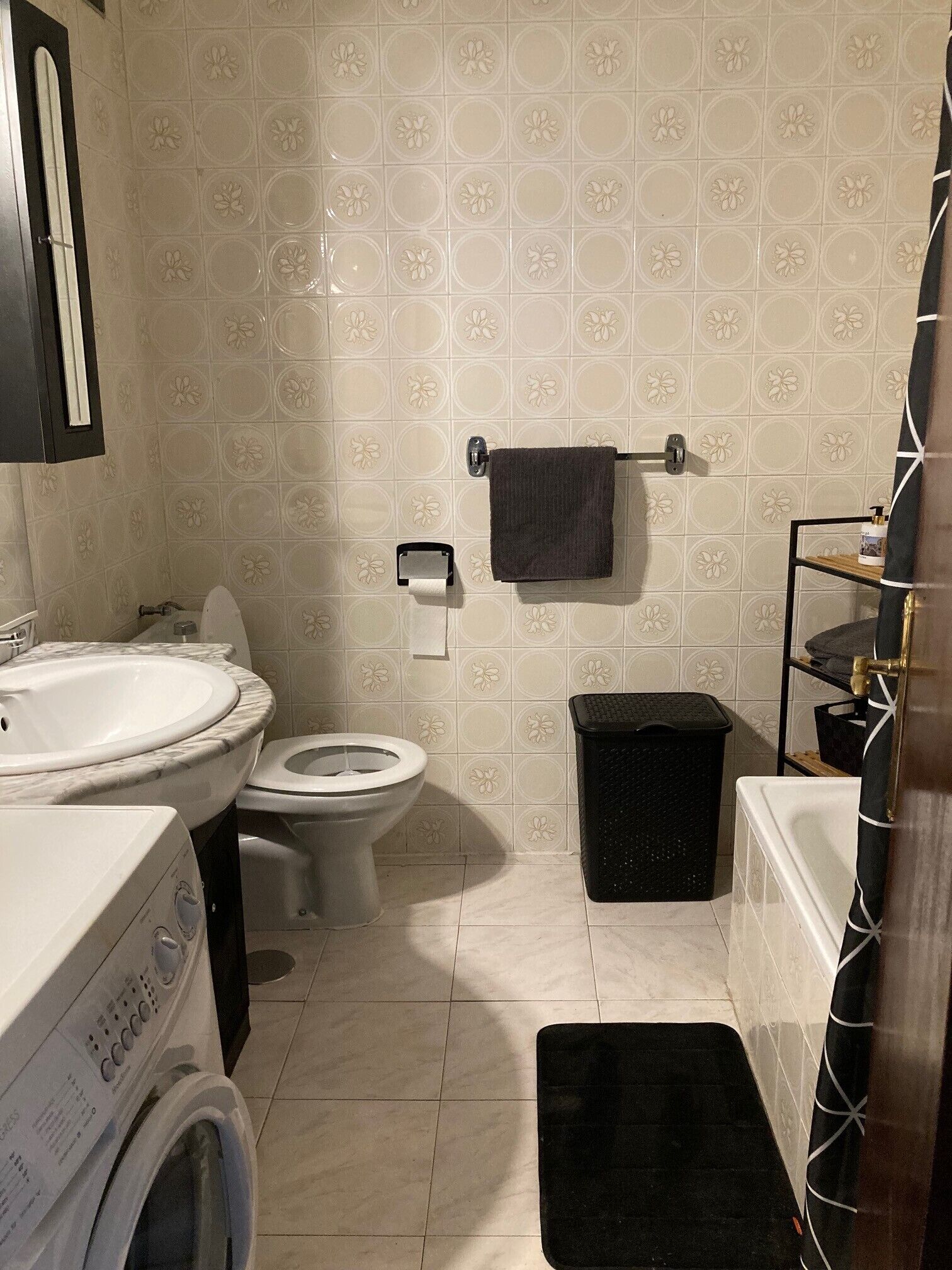 A bathroom with a toilet, sink, and washing machine.