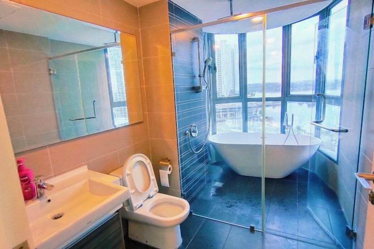 A modern bathroom with a bathtub, toilet, and sink.