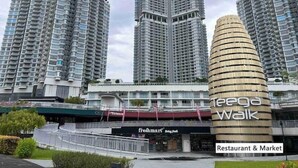 A modern high-rise building with a curved facade, a restaurant and market area below, and several other high-rise buildings in the background. - Teega Residence (Iskandar Puteri)