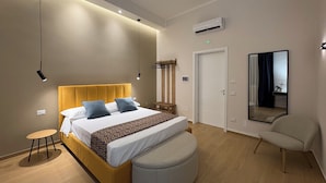 Une chambre d’hôtel moderne, équipée d’un lit, d’une table de chevet et d’un miroir.