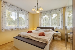 A bedroom with a bed, bedside tables, a nightstand, a dresser, a bench, and a mirror. - Apartment '2 Zimmer 69 Qm' with Shared Terrace, Shared Garden and Wi-Fi (Mittenwalde)