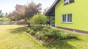 Een groen gebouw met een tuin ervoor.
