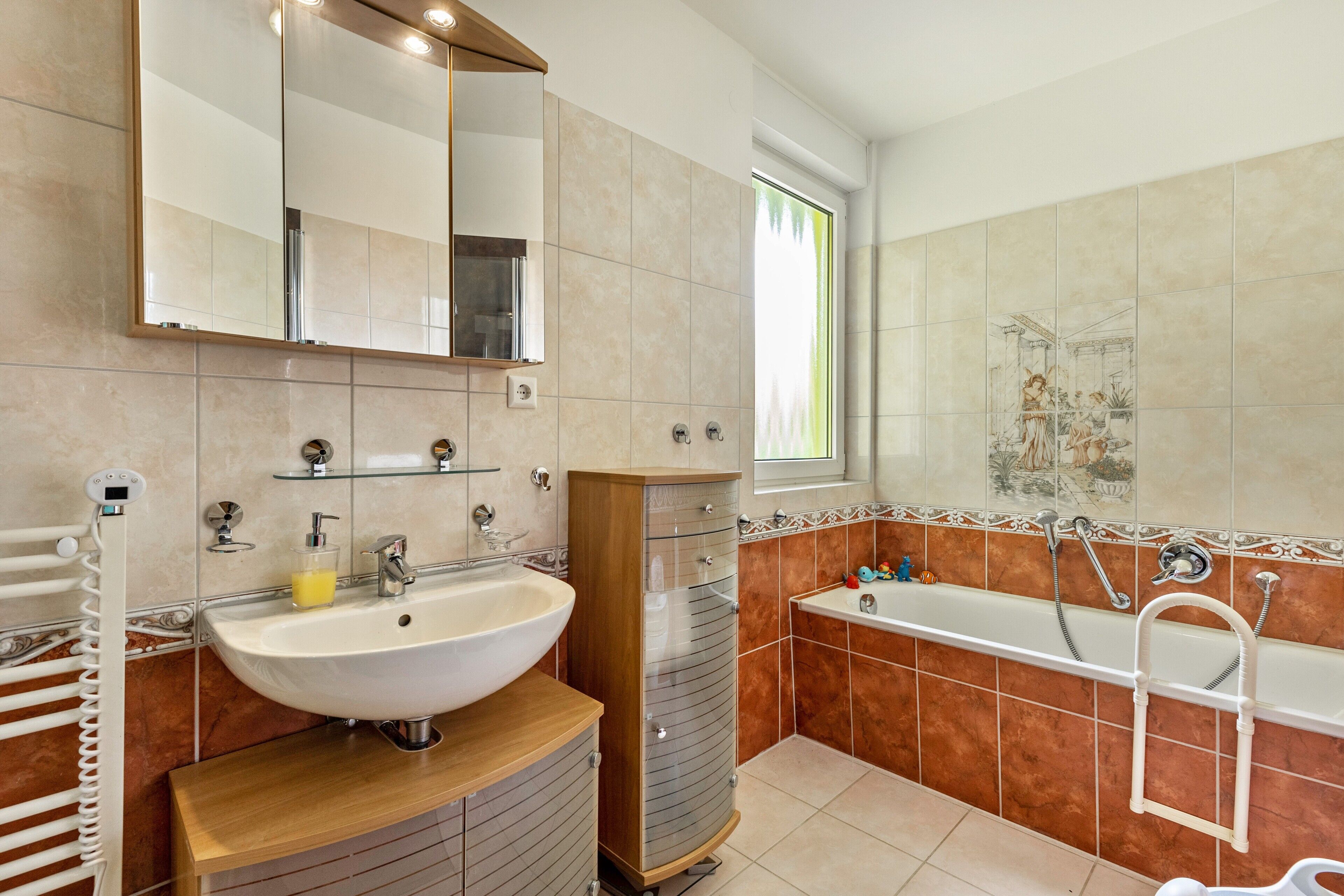 Ein Badezimmer mit Waschbecken, Spiegel, Waschtisch und Badewanne.