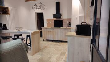 A modern kitchen with a central island, wooden cabinets, and a bicycle decoration on the wall.